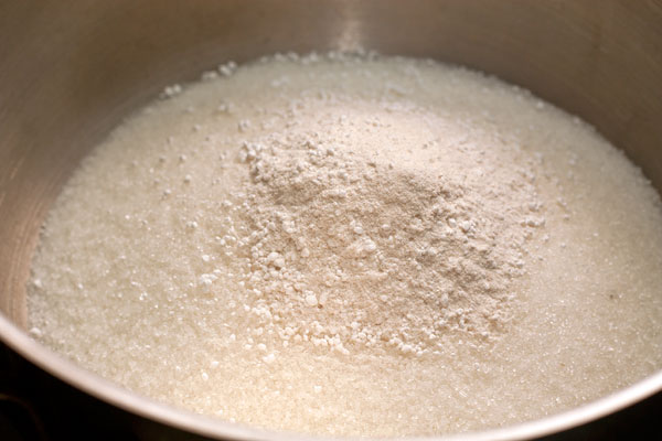 В кастрюлю для варенья насыпьте сахар и пектин. Можно использовать уже готовый желирующий сахар, который уже содержит пектин. Это позволит использовать меньшее количество сахара и сделать джем густым.