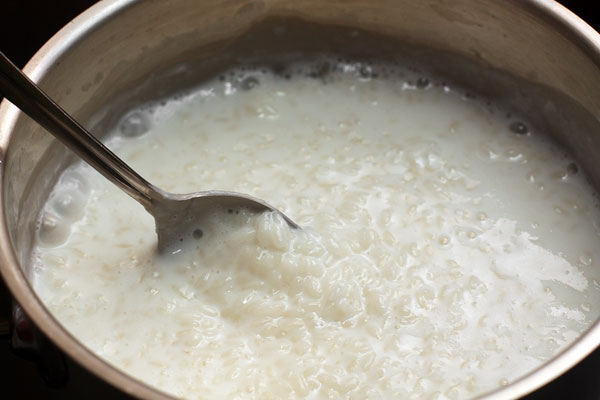 Подождите, пока каша загустеет, затем опять добавляйте молоко небольшими порциями, чтобы температура каши сильно не падала, а вам было легче контролировать степень готовности риса.  Посолите, добавьте сахар и продолжайте варить, подливая молоко, пока рис не станет мягким. Можно добавить немного ванильного экстракта.