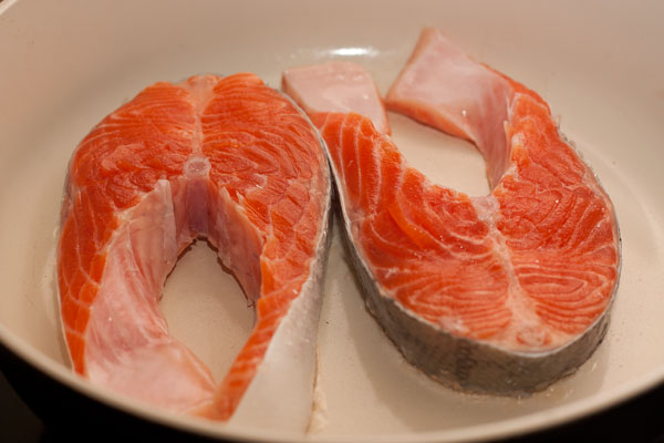 Рыбу разрежьте на стейки, посолите, поперчите и жарьте на сухой сковороде.