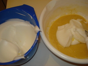Соедините муку , сахар, разрыхлитель, соль  и просейте все вместе через сито три раза. Соедините два желтка с тепленьким молоком , ванилью и цедрой одного лимона. Перемешайте так, чтобы получилась однородная масса. Взбейте сахар  с белками.  &#188;  часть белковой массы соедините с желтковомасляной смесью, аккуратно перемешивая снизу вверх. Введите остальные белки до образования воздушной бисквитной массы.