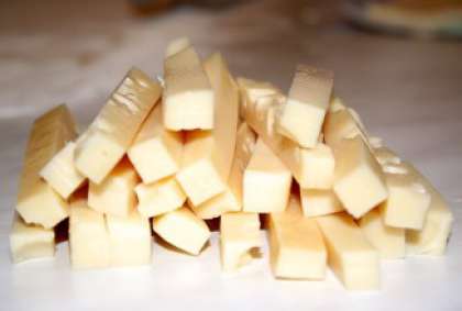 Отдельно нарежьте твердый сыр средними брусочками.