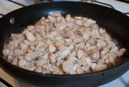 Теперь приготовим самостоятельно начинку. Куриное мясо нарежьте небольшими кусочками. Обжарьте на растительном масле, слегка поперчив и посолив, приблизительно 10 минут. По желанию можете добавить обжаренные с луком грибы. С ними тоже получается очень вкусно. Добавьте немного соевого соуса и смешайте грибы с обжаренным куриным мясом.