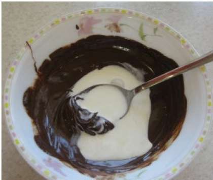 Пока кекс печется, приготовьте глазурь. Для этого растопите шоколад с маслом на водяной бане, добавьте сливки и перемешайте до образования однородной массы. Глазурь готова.
