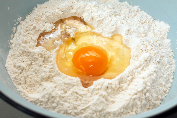В широкую миску просейте муку с солью, добавьте масло, яйцо и воду (130-150 мл). Замесите довольно мягкое тесто.