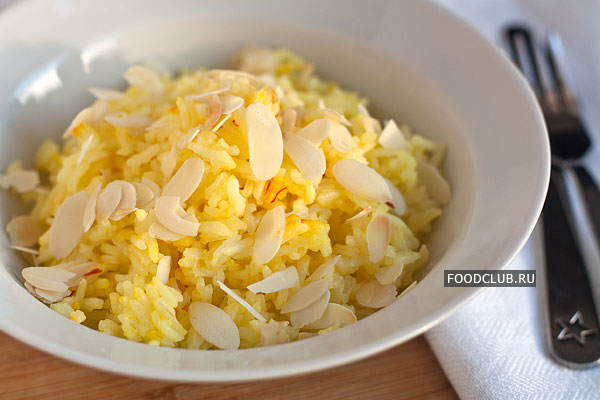 Разложите рис по тарелкам, посыпьте чуть поджаренными хлопьями миндаля.  Подавайте горячим в качестве гарнира или самостоятельного блюда.