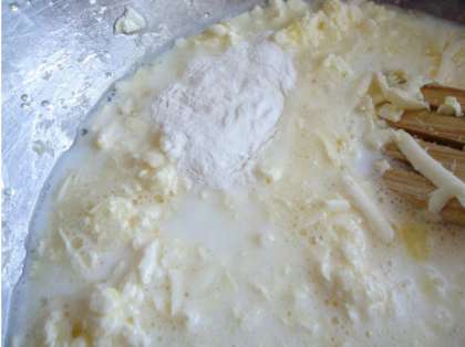 Теперь в маргариновую смесь влейте молоко и добавьте разрыхлитель. Постепенно насыпайте просеянную муку. Вымешивайте тесто до образования густой сметаны. Маргарин полностью не старайтесь растирать, в процессе выпекания внутри кекса будут аппетитные дырочки.