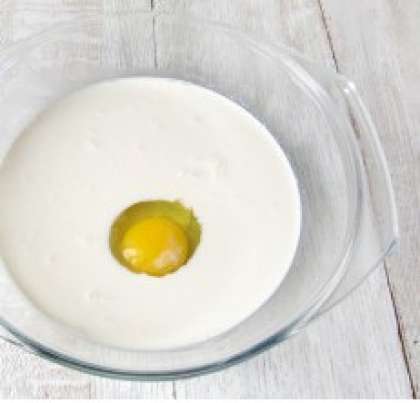 Взять миску среднего размера. Туда вылить два стакана теплого молока и вбить куриное яйцо.