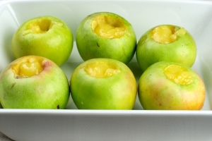 Выложите яблоки на противень, можно в жаропрочную форму и в серединку каждого  положите по 2 чайной ложки меда.