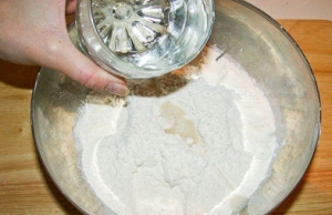 Муку просейте в большую простую миску, а затем сделайте там воронку и добавьте воду. Можно смешать воду и яйцо отдельно в стакане, а потом вылить в муку. Далее влейте масло растительное (оливковое), добавьте соль. Замешайте тесто своими руками. В конце оно должно получиться мягким.