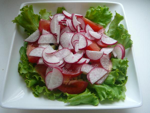 Рвем  руками салат, кладем в тарелку, выкладываем на него овощи.