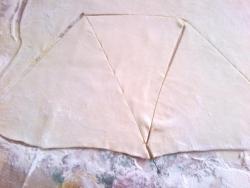 Готовое тесто тонко раскатайте и вырежете необходимых размеров  треугольники.