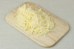 Приготовьте кусочек сыра. Для приготовления рулета, лучше всего подойдет сыр твердых сортов, например «Российский». Его также нужно натереть на терку (желательно крупную) в домашних условиях.