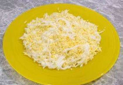 Возьмите глубокую миску и самостоятельно смешайте натертые вареные яйца и сыр. Посолите слегка начинку. Немного вкусного сыра оставьте для украшения блюда.