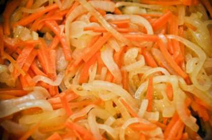 На растительном масле на раскаленной сковороде обжариваем соломкой нарезанный лук и морковь, потом на сковороду выкладываем сладкий перец. Все снова перемешиваем и обжариваем.