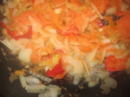 Тем временем, готовим на сковороде соус для пельменей. Обжариваем мелко нарезанный лук,  а когда лук дойдет до золотистого цвета, добавляем к нему нарезанную соломкой морковку. Когда лук с морковкой немного обжарятся, то к ним добавляем сладкий перец, нарезанный соломкой. Все тушим на медленном огне, если овощи начинают пригорать, то нужно добавить немного бульона от пельменей.