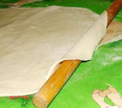 Раскатать тесто в большой пласт формы прямоугольника, толщиной не более 1см. Оставляем тесто немного полежать.