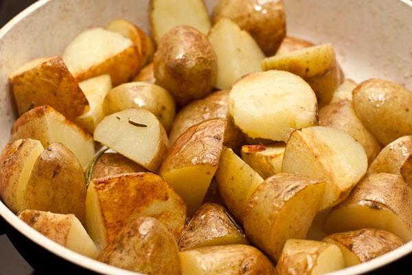 Добавьте в сковороду масло и обжаривайте на средне-сильном огне, периодически помешивая, чтобы картошка равномерно обжарилась со всех сторон.