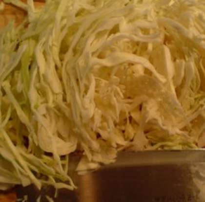 Пока лук поджаривается, начинаем нарезать тонкими полосками нашу белокочанную капусту.