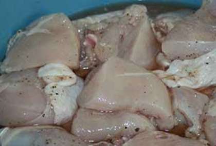 Каждый кусочек курицы нужно обязательно равномерно посолить, поперчить и вложить в глубокую посуду. После того как вы это сделали, следует добавить к курице натертый лук и все это тщательно перемешать.