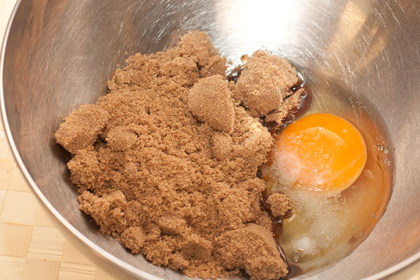 В миске соедините яйцо и мелкий темно-коричневый сахар.