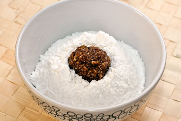 Чайной ложкой берите понемногу смесь, обваливайте ее в сахарной пудре и катайте шарики размером примерно с грецкий орех.