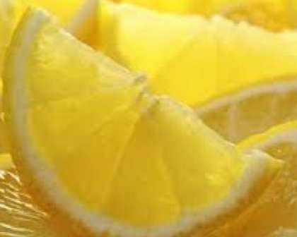 Потом помойте лимон. Обсушите его и разрежьте пополам. Порежьте половинки лимона на дольки. Положите также по дольке лимона в каждую баночку с будущим компотом из крыжовника.