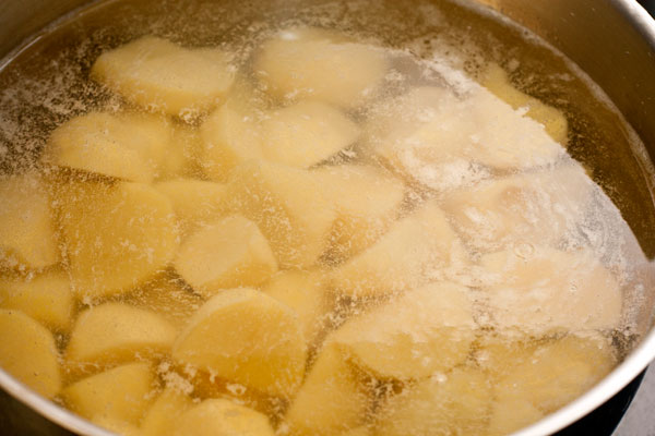 Почистите картофель, нарежьте крупными кубиками и варите до полуготовности в подсоленной воде. В зависимости от размера кусочков это займет 5-10 минут с момента закипания. Затем слейте воду.