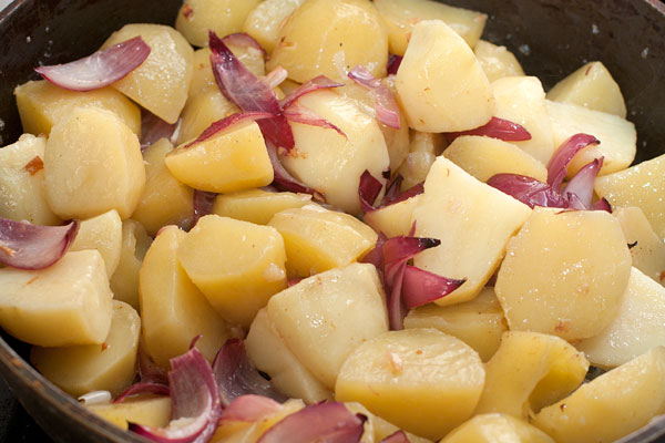 В сковороду добавьте картофель, перемешайте, чтобы он равномерно покрылся маслом и жарьте на среднем огне, неплотно прикрыв крышкой около 25 минут. Несколько раз осторожно перемешайте в процессе приготовления.  Посолите и поперчите по вкусу.
