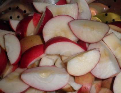 Помойте яблоки. Затем разрежьте их на две половинки, потом  удалите семечки и перегородки. После этого нарежьте яблоки дольками, однако не сильно мелко. Также бланшируйте их, как и виноград (минуты 3-4). После этого положите их в банки к винограду.