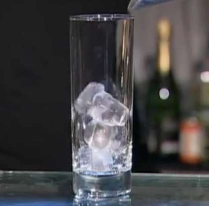 Возьмите бокал для подачи коктейля (хайболл). Прежде всего, положите в него кубики льда, практически до самого верха.