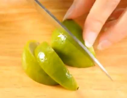 Прежде чем нарезать, помойте лайм. Затем разрежьте его пополам. Возьмите половинку цитруса и нарежьте его дольками.