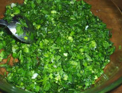 В миску насыпьте зелень, слегка посолите, разомните, чтобы она дала сок. Потом положите зеленый лук, а также чеснок измельченный ранее. Все это тщательно перемешайте.