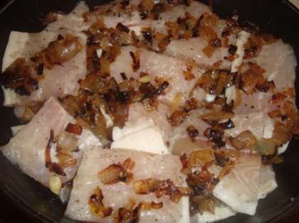 Разморозьте филе пангасиуса, нарежьте его на порционные кусочки. Уложите порезанное филе в глубокую миску, выдавите в неё половину лимона. Посыпьте солью и перцем. Поджарьте лук и добавьте его в миску с рыбным филе, перемешайте. Самые жирные кусочки уложите на дно, чтобы жир вытопился.