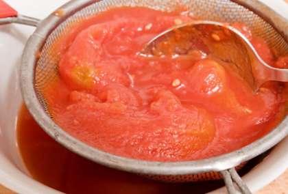 Томаты для соуса помойте. Затем надрежьте их в верхней части плода. Бросьте их в кипящую воду на минуты две, а потом выньте. Охладите и снимите кожицу с помидоров. Возьмите сито, затем, и протрите очищенные таким образом томаты.