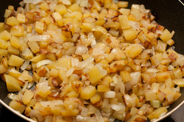 Посолите и готовьте на небольшом огне, постоянно помешивая, до готовности картофеля.