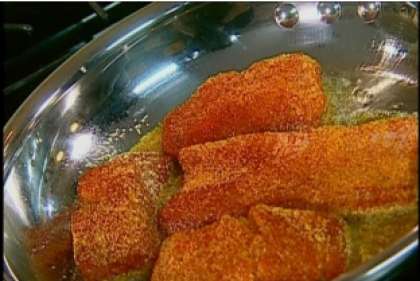 Поставьте сковородку на огонь заранее. Налейте растительного масла в разогретую сковородку. Выложите запанированные кусочки лосося на дно посуды. Обжарьте их до готовности.