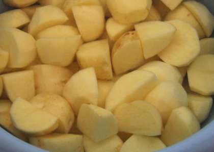 Картофель помойте. Очистите кожуру с клубней. Затем порежьте картошку кубиками произвольной величины.