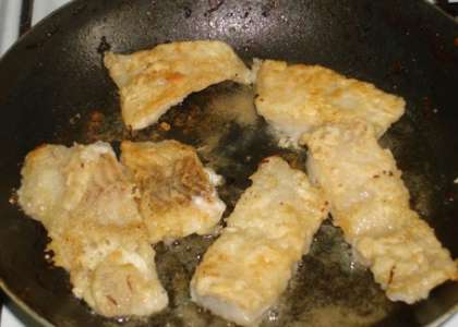 Затем выложите обвалянные в муке и соли  куски рыбы на сковороду и обжарьте с двух сторон на хорошо разогретой с растительным маслом сковороде. Накройте сковороду крышкой, чтобы рыба получилась более нежной и хорошо прожарилась.