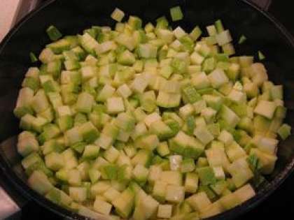 Заранее поставьте сотейник (сковороду) на плиту и разогрейте в нем масло растительное. Кабачки выложите на дно сотейника. Перемешайте. Овощи тушите минут десять.