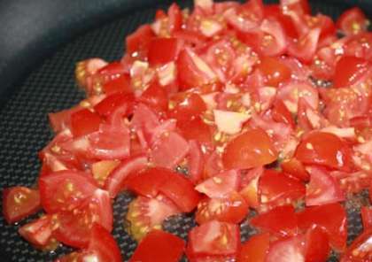 Потом на ту же сковороду выложите порезанные помидоры. Их нужно обжаривать, постоянно помешивая, пока они не размягчатся до консистенции пюре. Добавьте чеснок в помидоры.