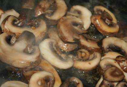 Помытые шампиньоны порежьте пластинками. Обжарьте грибы на сковороде.
