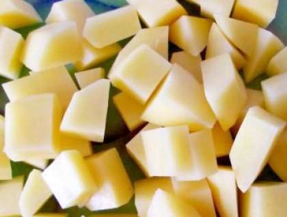 С вымытого картофеля снимите кожуру. Потом нарежьте его кубиками, как морковь и лук.