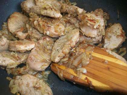 Когда лук и мясо хорошо обжарятся, выключите огонь и выложите готовые кусочки свинины с луком в тарелку.