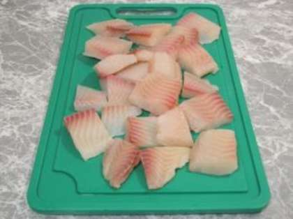 Вымойте и обсушите рыбное филе, затем нарежьте его небольшими кусочками (порционными).
