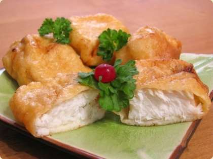 Готовую жареную рыбу в кляре выложите в тарелку и подайте к столу, посыпав свежей зеленью. 