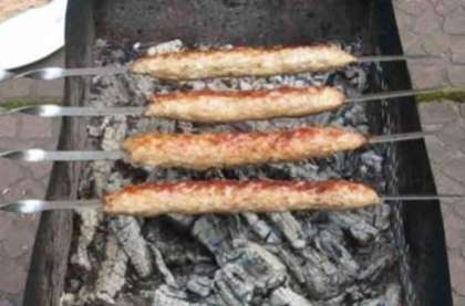 Обжарьте куриный люля-кебаб на горячих углях до румяной корочки, при этом постоянно поворачивайте шампура.