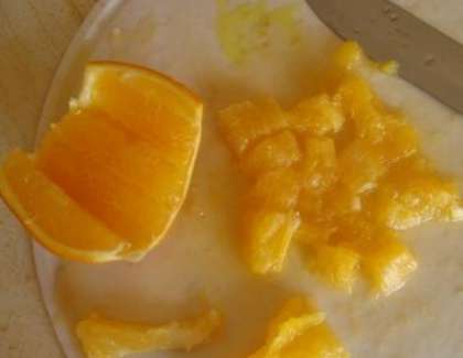 Пока мясо тушиться, помойте апельсины. Очистите их от кожуры. У одного апельсина ужалите перегородки и тонкую кожицу. Аккуратно разделите его на дольки и порежьте кубиками. А с другого апельсина отожмите сок.