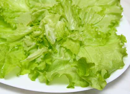 Возьмите листья салата, какие вам больше нравятся. Вымойте и выложите на центр широкой тарелки.