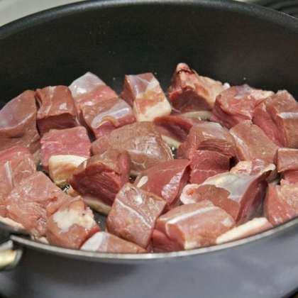Возьмите глубокую сковороду, разогрейте её без масла, затем добавьте масло в небольшом количестве и выложите в сковороду все порезанное мясо.