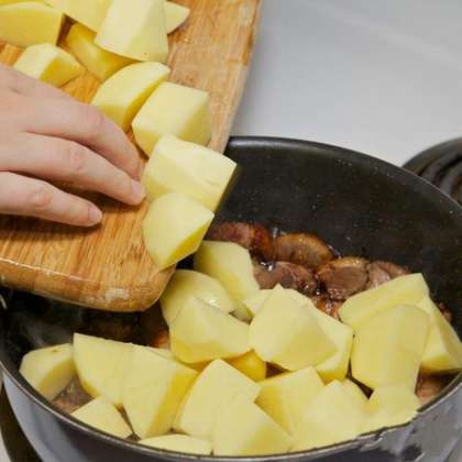 Добавьте в сковороду к утке порезанный картофель, и готовьте все вместе, время от времени помешивая содержимое сковороды.